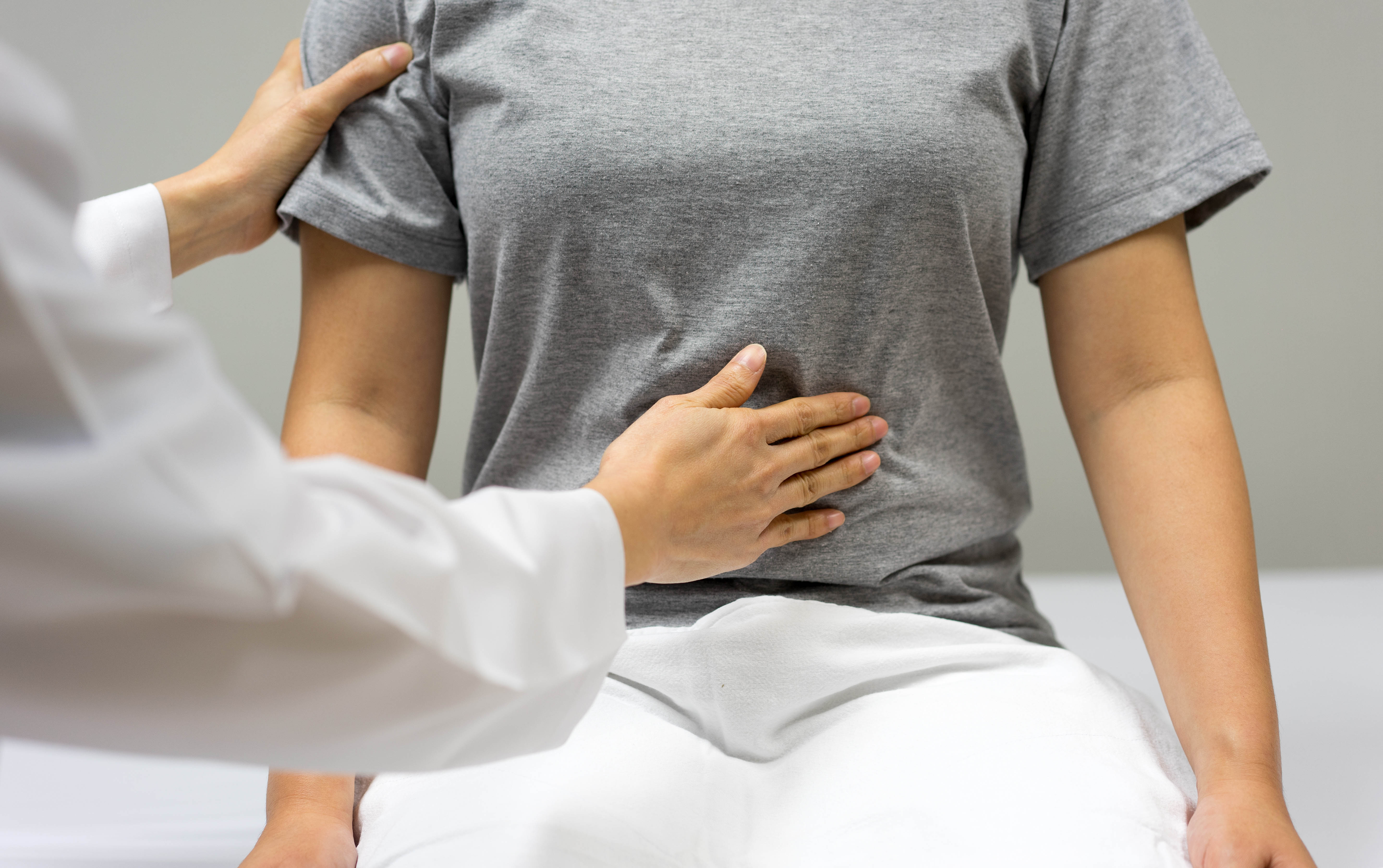 Young woman at a doctor's office having a physical exam around her belly